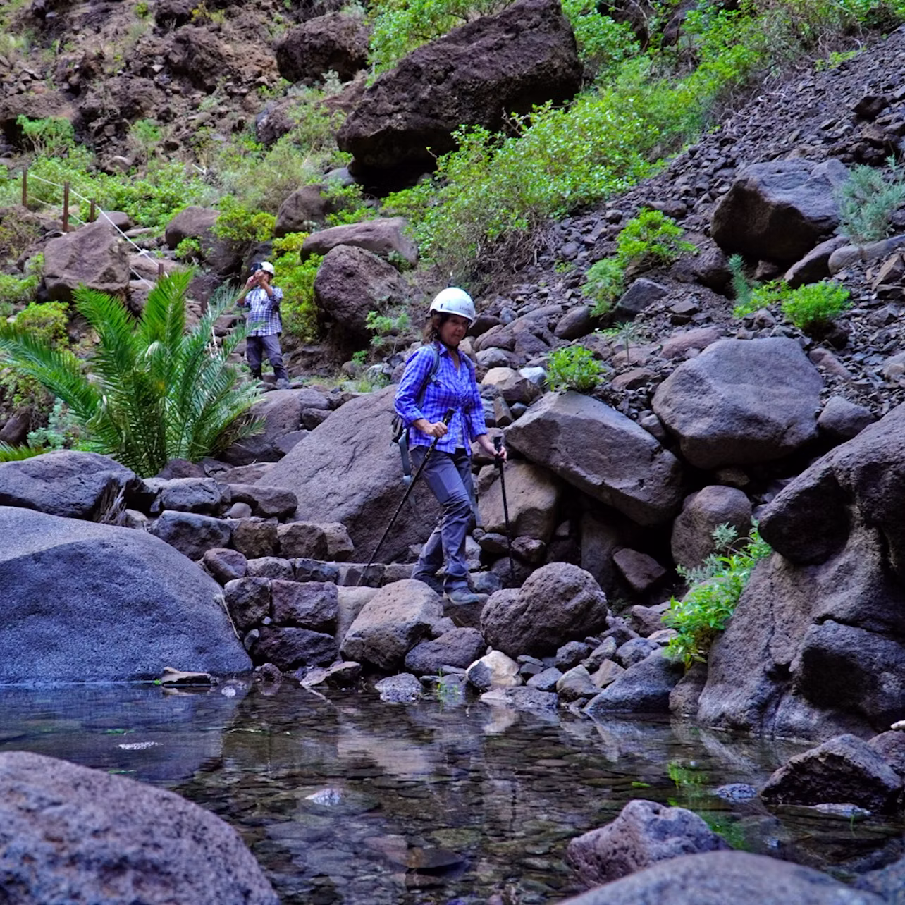Couple going down the ravine and photographing the landscape