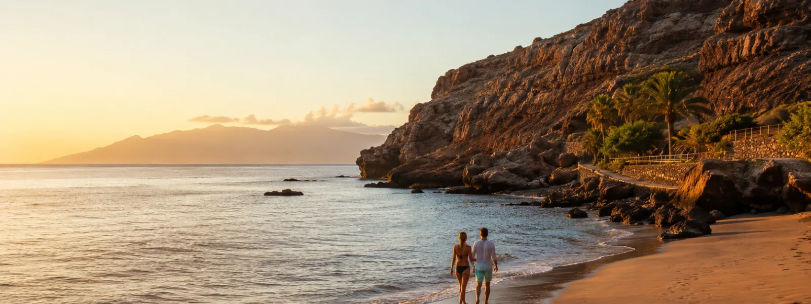 Couple marchant sur une plage tranquille de Tenerife au coucher du soleil avec des falaises volcaniques et l'océan Atlantique