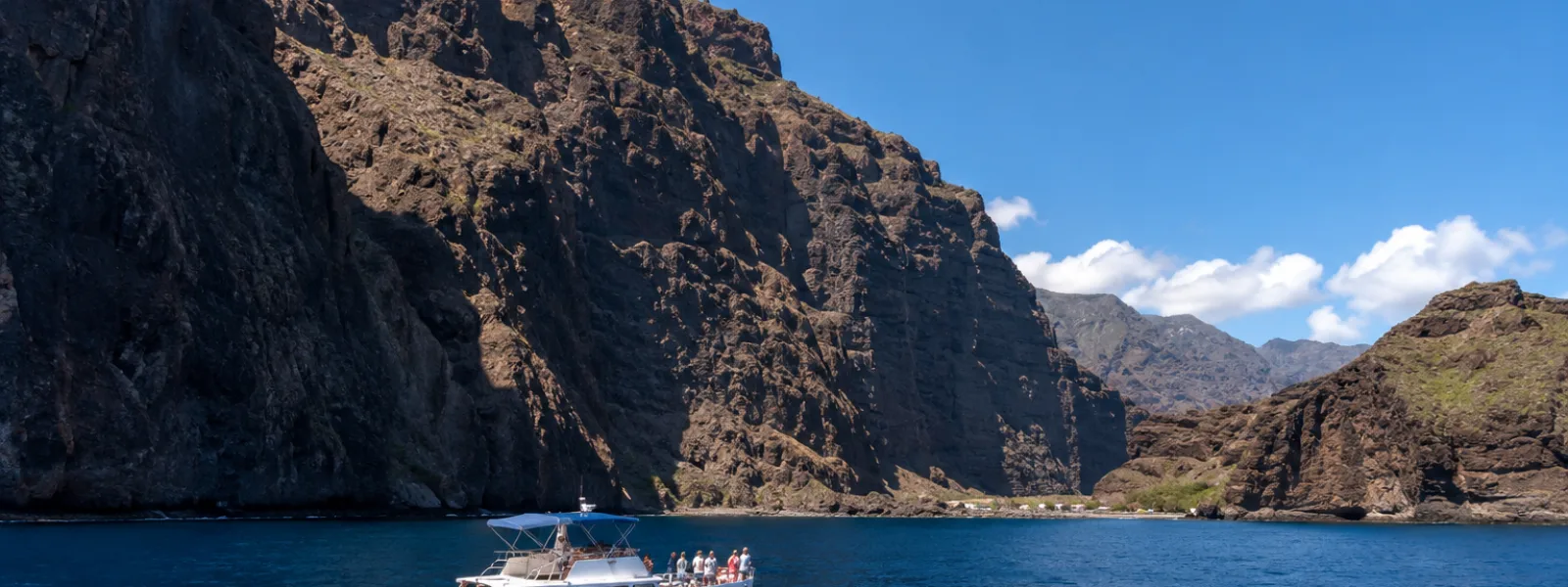 Kleine boot die vaart onder de kliffen van Los Gigantes nabij Masca Bay op Tenerife