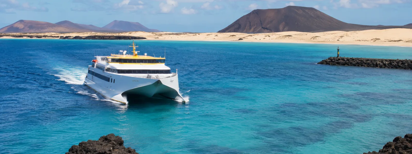 Traversée en ferry entre Lanzarote et Fuerteventura avec vue sur les dunes de Corralejo et la mer Atlantique