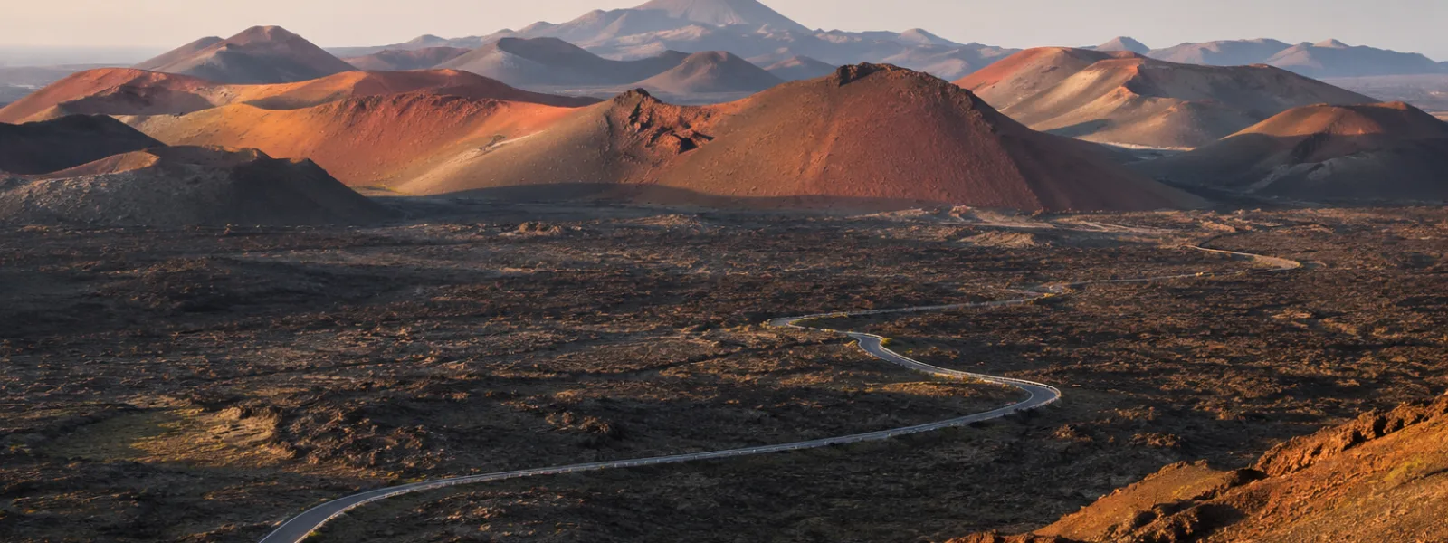 Paysage volcanique du parc national de Timanfaya à Lanzarote avec des cratères rouges et des champs de lave noire