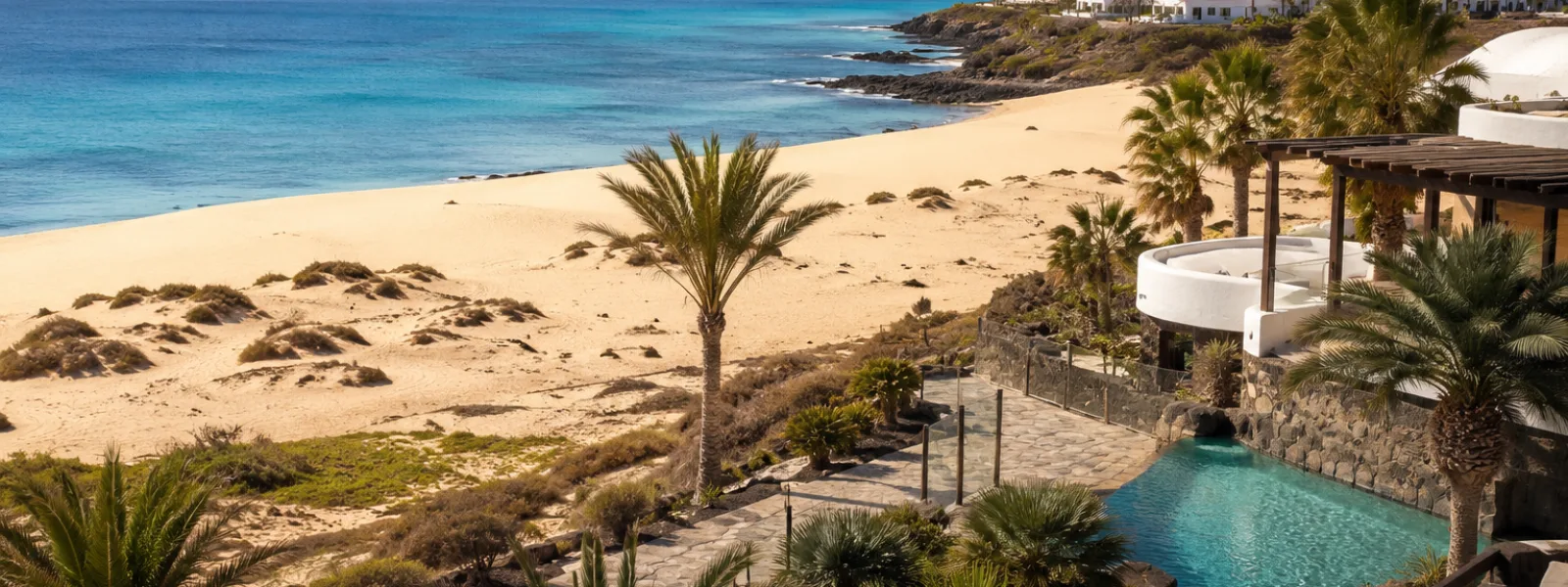 Kustlijn van resort op Fuerteventura met duinen en turquoise Atlantisch water