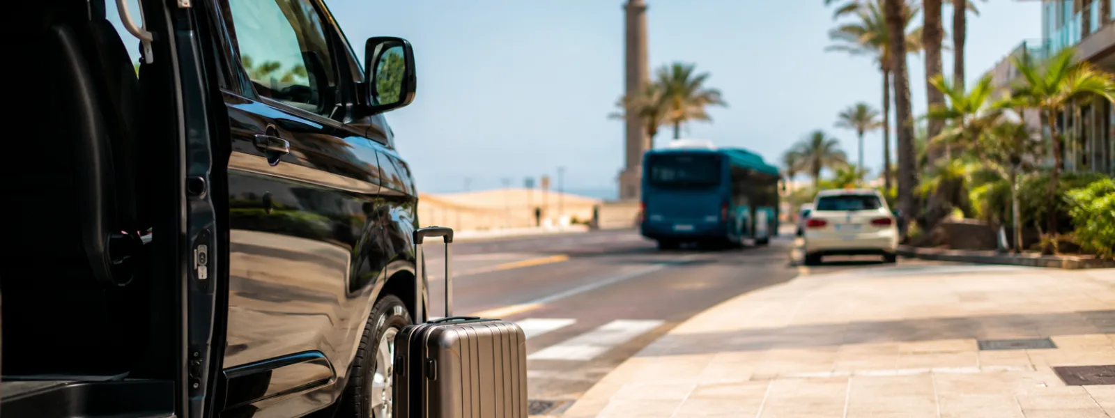 Veicolo di trasferimento aeroportuale e bagagli con le dune di Maspalomas e lo scenario del resort di Meloneras a Gran Canaria