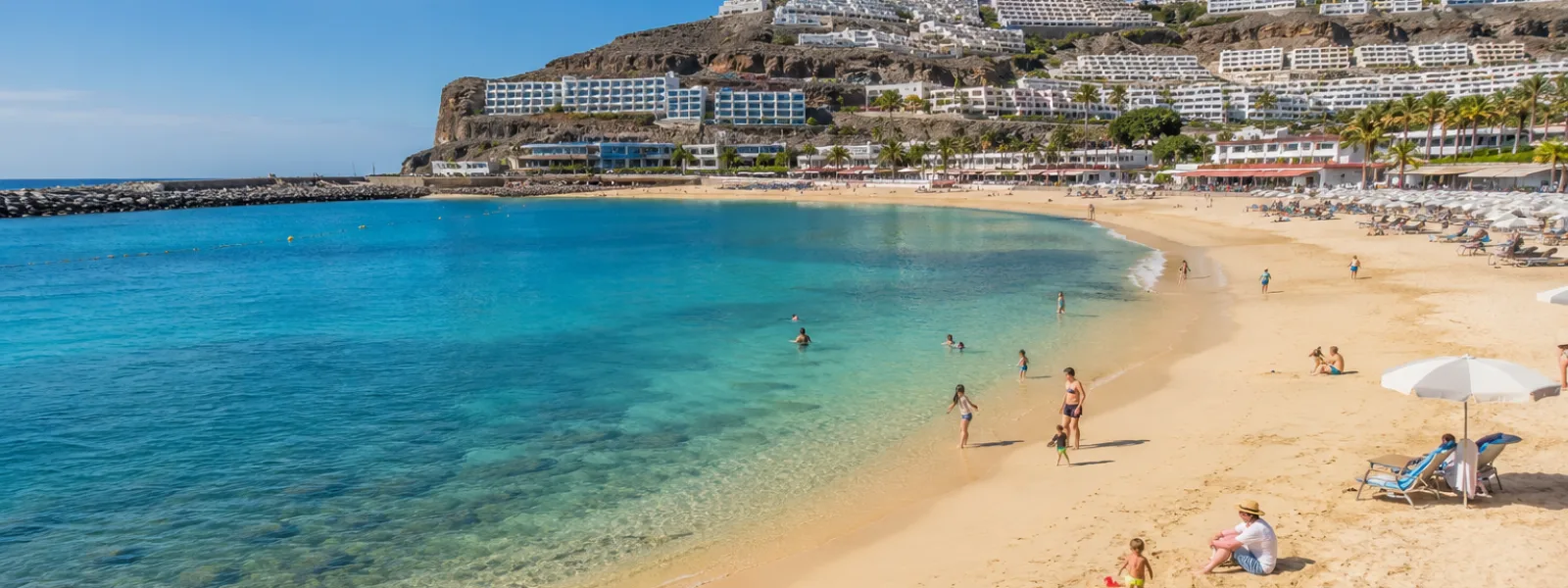 Plage de station familiale dans le sud de Gran Canaria avec des eaux calmes et des hôtels