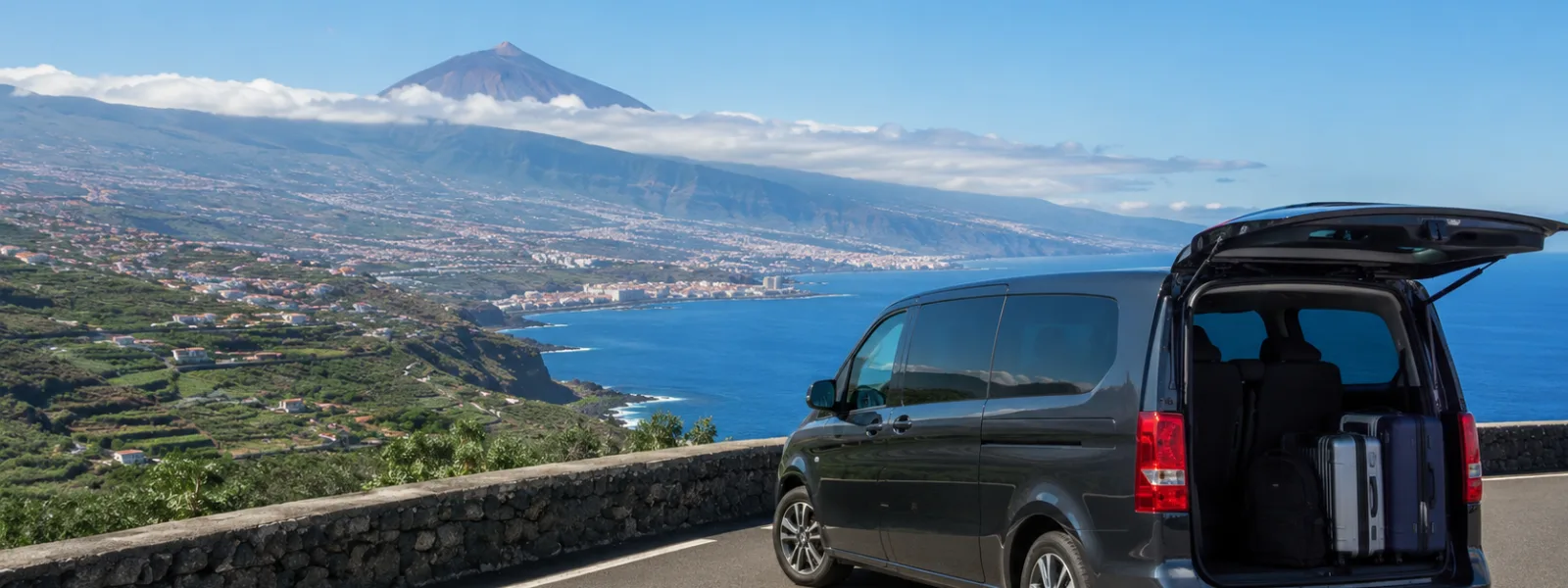 Transfer car on a scenic Tenerife road towards Puerto de la Cruz with the Orotava Valley and north coast in the distance