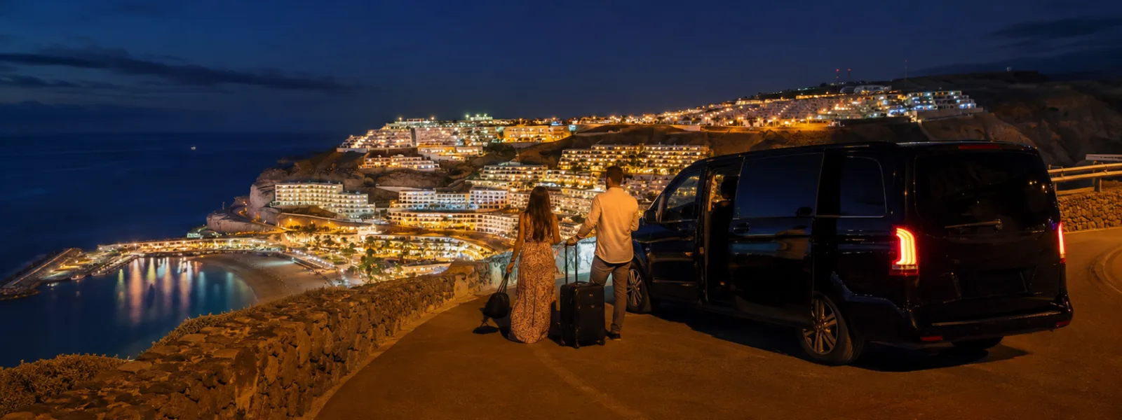 Privétransfer 's nachts boven de verlichte kustlijn van Puerto Rico en Amadores op Gran Canaria