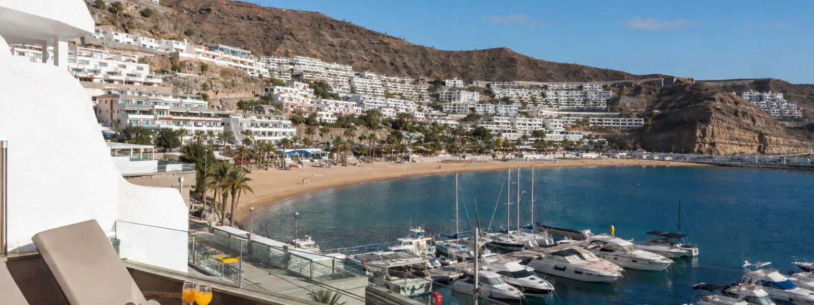 Puerto Rico marina, beach and aparthotels on the sunlit Gran Canaria valley