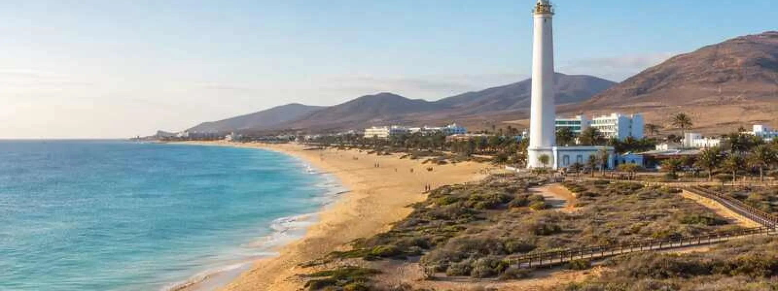Playa del Matorral and Morro Jable lighthouse beside beachfront hotels in Jandía, Fuerteventura