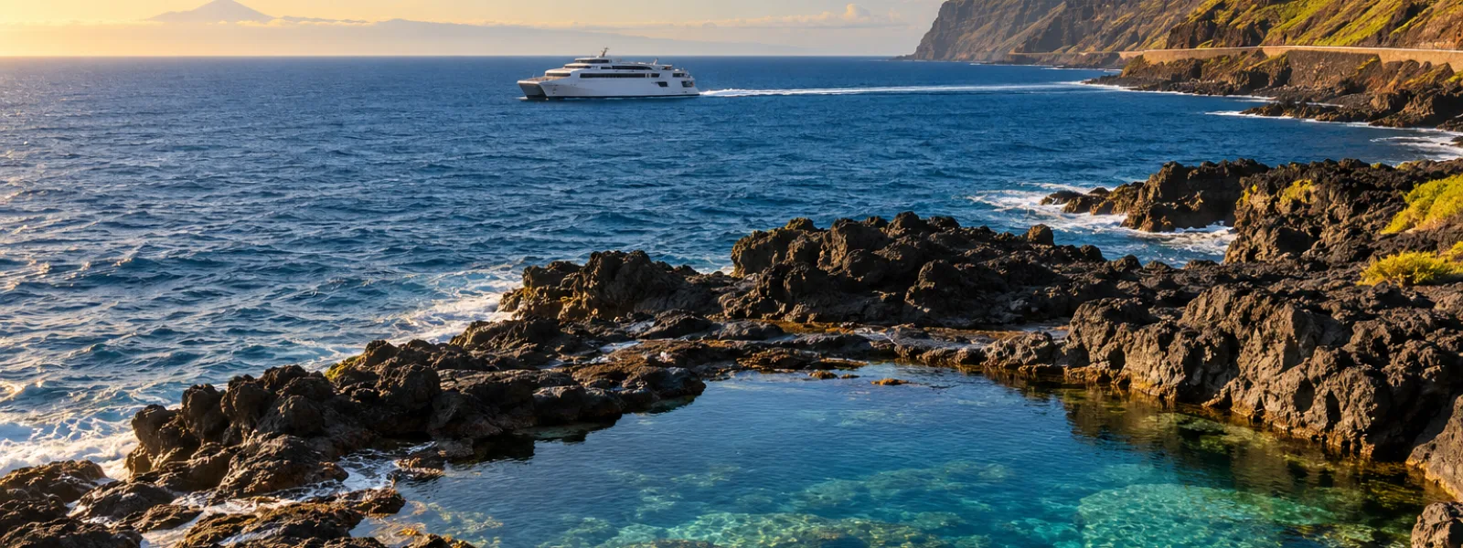 Fast ferry passing El Hierro's volcanic coast and natural pools with distant Tenerife on the horizon