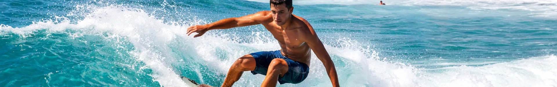 Surfeur sur une vague aux îles Canaries avec un paysage volcanique en arrière-plan