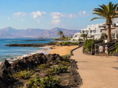 Winter sun resort promenade in Lanzarote with volcanic hills and white coastal architecture