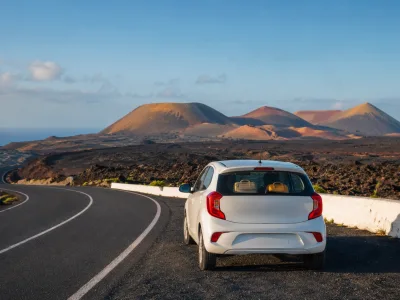 Compact rental car on a volcanic road in Lanzarote for a car hire travel guide