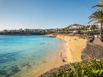 Families enjoying the sheltered Playa Dorada beach near resort hotels in Playa Blanca, Lanzarote