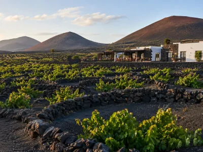 Volcanic vineyards in La Geria, Lanzarote, with traditional vine pits and winery scenery