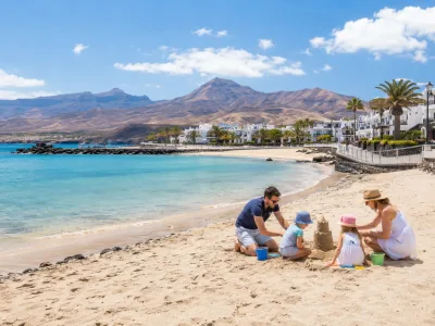 Family with young children on a calm Canary Islands beach resort