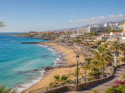 Costa Adeje beach hotel areas with golden sand, palm promenade and resort hotels in Tenerife