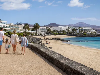 Family walking beside Los Pocillos and Matagorda beaches in Puerto del Carmen, Lanzarote