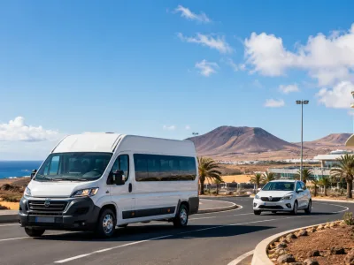 Airport transfer minibus and rental car on a sunny road in Fuerteventura