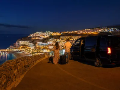 Private transfer at night above the lit Puerto Rico and Amadores coastline in Gran Canaria