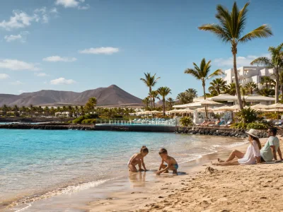 Family enjoying a sunny Canary Islands beach resort during a May half-term holiday