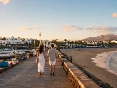 Couple walking between Puerto del Carmen Old Town harbour and Playa Grande in Lanzarote