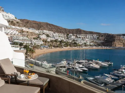 Puerto Rico marina, beach and aparthotels on the sunlit Gran Canaria valley