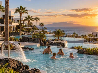 Family enjoying a luxury resort pool at sunset in Playa Paraiso, Tenerife