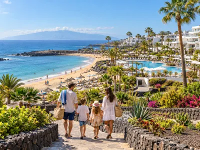 Family walking through a Costa Adeje resort toward a sandy Tenerife beach