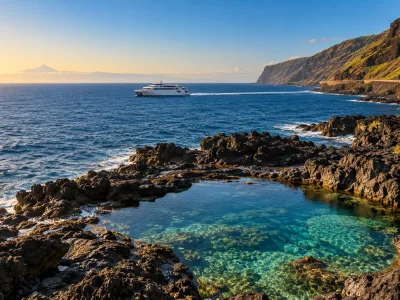 Fast ferry passing El Hierro's volcanic coast and natural pools with distant Tenerife on the horizon