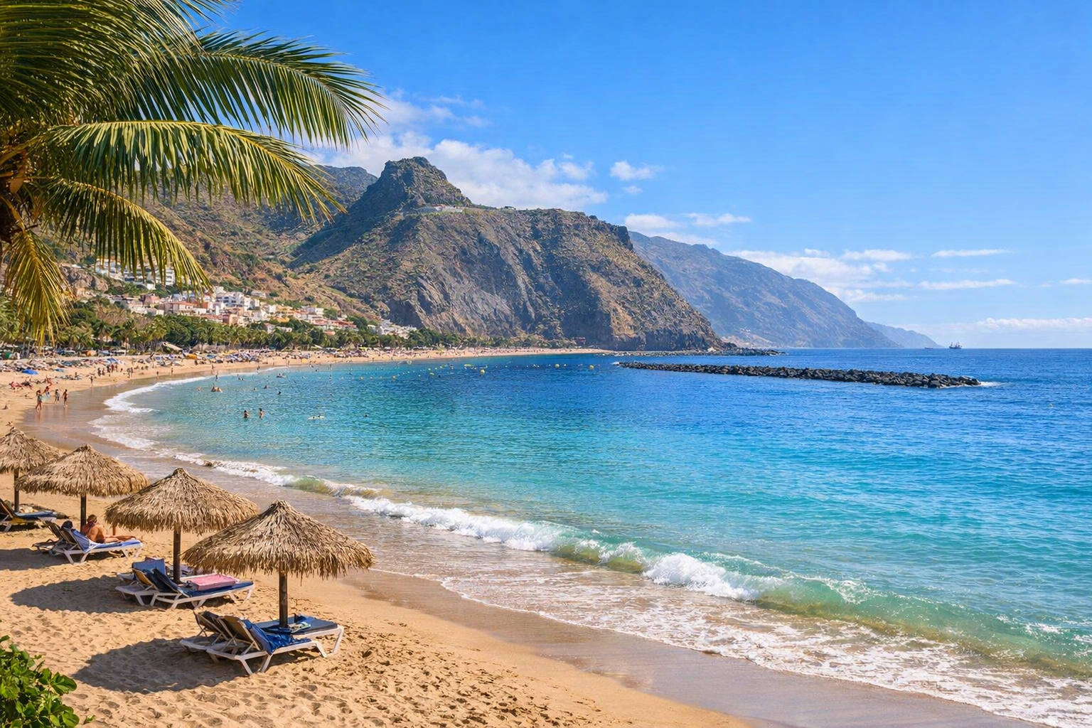 Sunny beach in Tenerife with golden sand, turquoise water and mountain backdrop