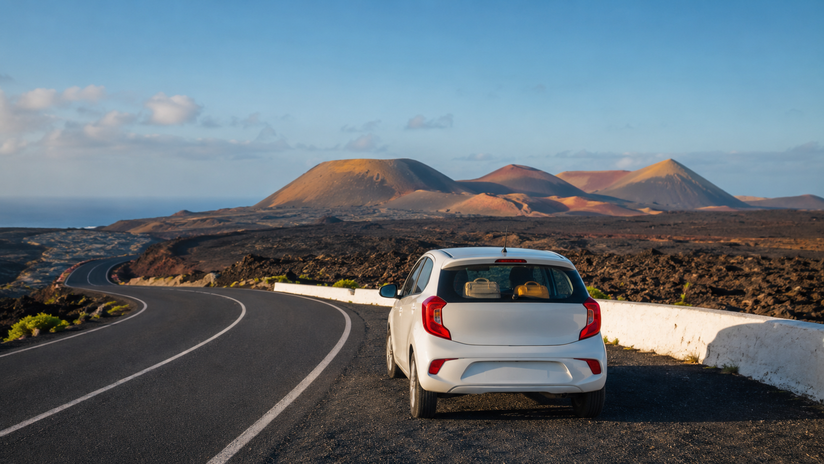 Compact rental car on a volcanic road in Lanzarote for a car hire travel guide