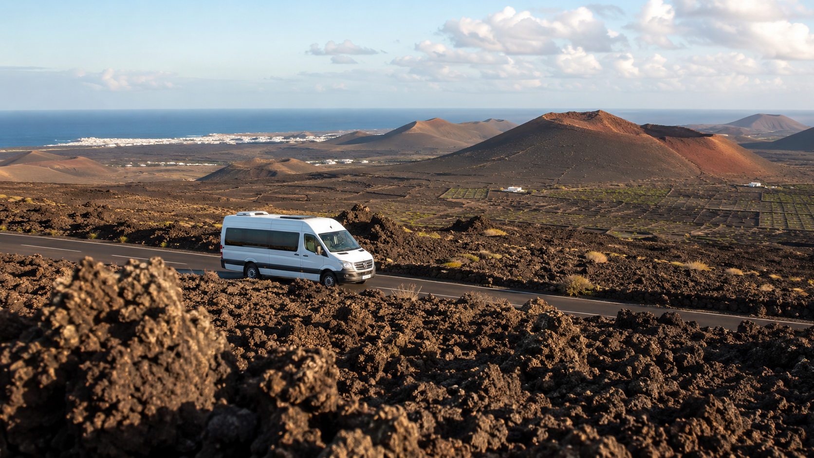Volcanic Lanzarote landscape with a tour minibus, representing excursions from Playa Blanca, Puerto del Carmen and Costa Teguise