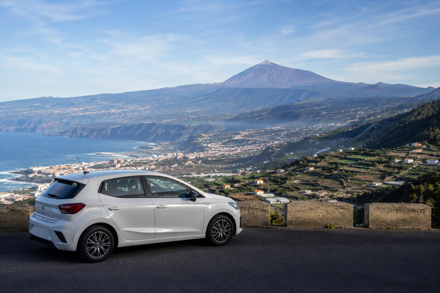 Rental car at a north Tenerife viewpoint above Puerto de la Cruz with Mount Teide in the distance