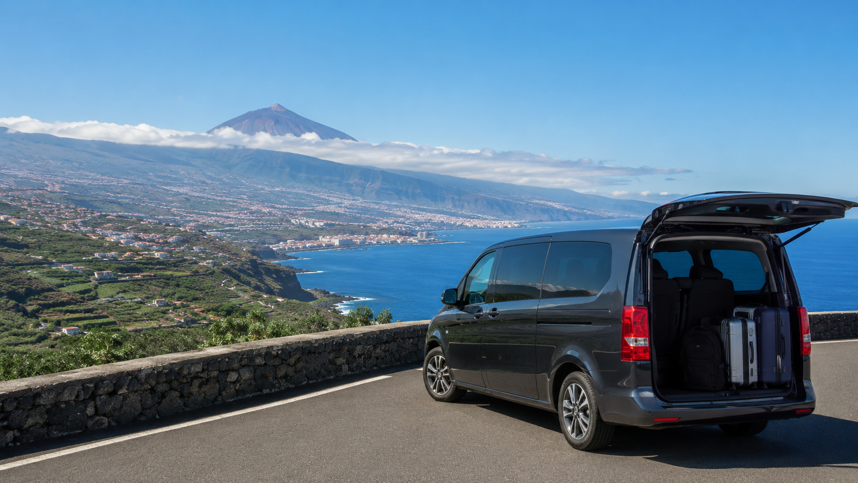Transfer car on a scenic Tenerife road towards Puerto de la Cruz with the Orotava Valley and north coast in the distance