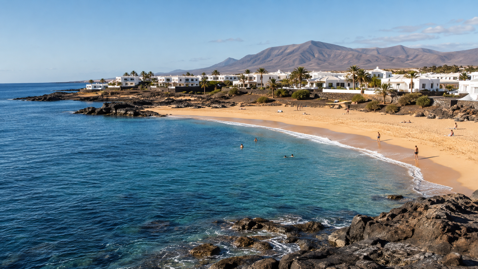 Sunny Canary Islands beach with volcanic rocks and whitewashed resort buildings in September