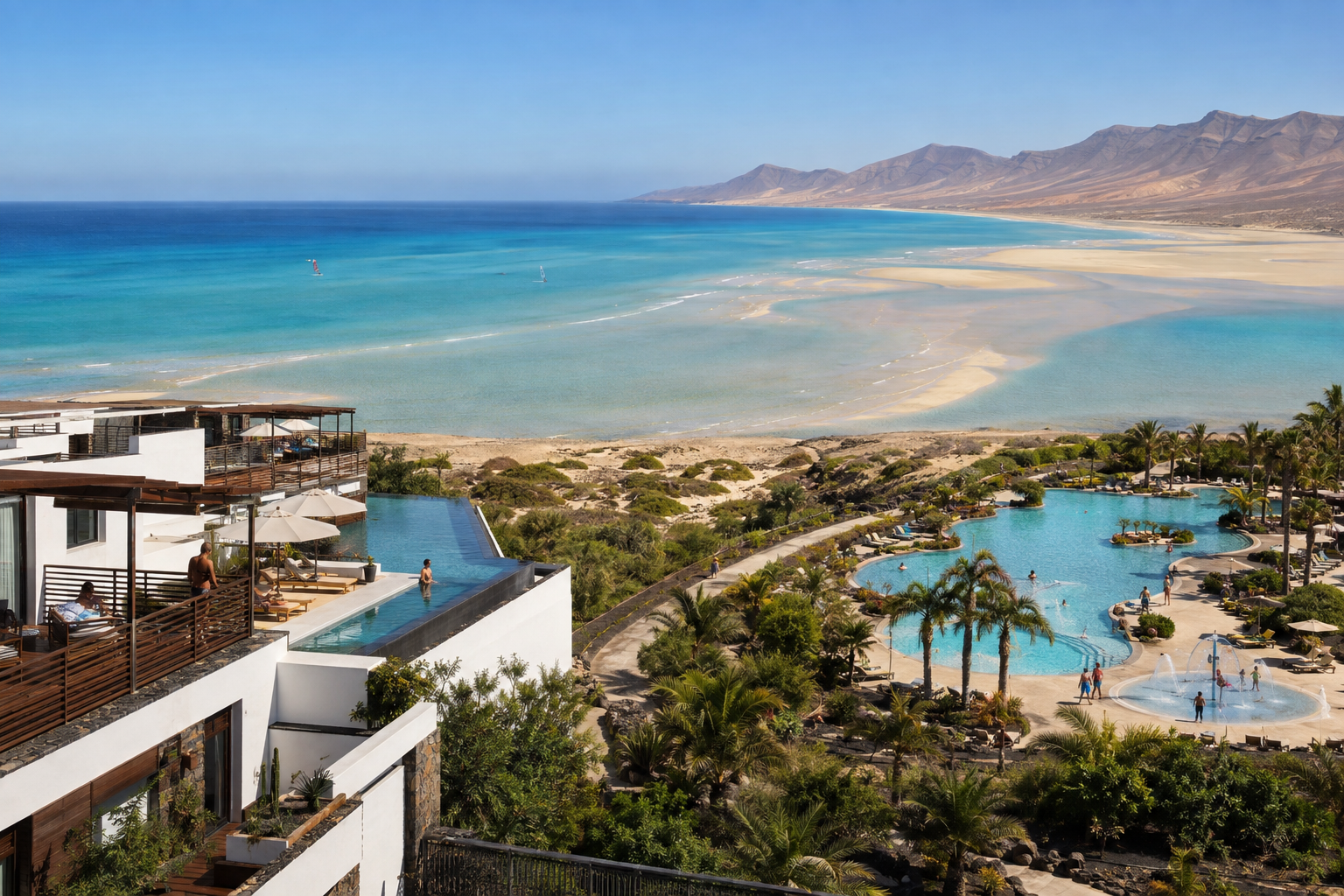 Aerial view of two contrasting beachfront resorts beside the turquoise tidal lagoon at Sotavento, Fuerteventura